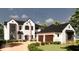 Two-story home with white brick, black roof, and three-car garage at 17710 Broad St, Montverde, FL 34756