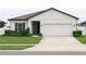 White one-story house with dark gray accents and two-car garage at 1637 Hill Park Dr, Deltona, FL 32725