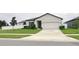 White one-story house with dark gray accents and two-car garage at 1637 Hill Park Dr, Deltona, FL 32725