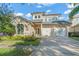 Two story house with three car garage and manicured landscaping at 7491 Gathering Dr, Reunion, FL 34747