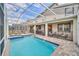 Inviting pool area with screened enclosure, patio furniture, and spa at 730 Drop Shot Dr, Davenport, FL 33896