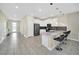 Open concept kitchen with breakfast bar, stainless steel appliances, and gray tile floors at 730 Drop Shot Dr, Davenport, FL 33896