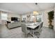 Modern dining room with a white table and grey chairs, and views into living room and backyard at 730 Drop Shot Dr, Davenport, FL 33896