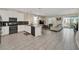 Open concept kitchen with white cabinets, modern appliances, and gray tile floors at 730 Drop Shot Dr, Davenport, FL 33896
