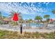 Community pool with lounge chairs and red umbrellas at 730 Drop Shot Dr, Davenport, FL 33896