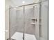 Large walk-in shower with gray tile and built-in shelves at 730 Drop Shot Dr, Davenport, FL 33896