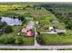 Aerial view of a rural property with multiple buildings and a pond at 350 S 5Th St, Orlando, FL 32833