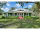 Green house with white trim, red porch, and lush landscaping at 350 S 5Th St, Orlando, FL 32833
