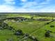 Aerial view of a vast property featuring pastures, trees and a pond at 350 S 5Th St, Orlando, FL 32833