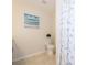 Clean bathroom with toilet, shower, and beach themed decor at 4721 Clock Tower Dr # 207, Kissimmee, FL 34746