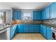 Kitchen with blue cabinets, granite countertops, and a tile backsplash at 1911 Betsy Ross Ln, Saint Cloud, FL 34769