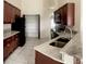 Kitchen with dark brown cabinets, granite countertops, and stainless steel appliances at 2688 Hawthorne Ln, Kissimmee, FL 34743