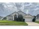 Tan house with a two-car garage and landscaping at 2688 Hawthorne Ln, Kissimmee, FL 34743