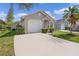 Tan house with a white garage door and palm trees at 1957 Teaberry Ct, Orlando, FL 32824