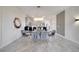 Elegant dining room featuring a glass table, grey chairs, and a modern chandelier at 543 Ocean Course Ave, Davenport, FL 33896