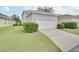 Detached garage with white door and landscaping at 7041 Buttonbush Loop, Harmony, FL 34773