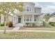 Two-story house with gray siding, front porch, and well-maintained landscaping at 7041 Buttonbush Loop, Harmony, FL 34773