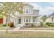Two-story home featuring a front porch, landscaping, and a gray exterior at 7041 Buttonbush Loop, Harmony, FL 34773