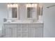 Double vanity bathroom with white cabinets and mirrors at 7041 Buttonbush Loop, Harmony, FL 34773