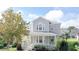 Two-story home with gray siding, a front porch, and a well-maintained lawn at 7041 Buttonbush Loop, Harmony, FL 34773