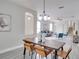 Open concept dining room with a rustic wooden table and modern light fixture at 7041 Buttonbush Loop, Harmony, FL 34773