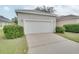 Detached garage with white door and landscaping at 7041 Buttonbush Loop, Harmony, FL 34773