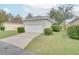 Detached garage with white door and landscaping at 7041 Buttonbush Loop, Harmony, FL 34773