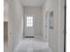 Clean and bright foyer with white tiled floor and neutral walls at 7041 Buttonbush Loop, Harmony, FL 34773