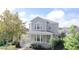 Two-story house with a gray facade, front porch, and landscaping at 7041 Buttonbush Loop, Harmony, FL 34773
