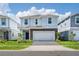 Two-story house with light gray siding, gray stone accents, and a two-car garage at 3955 Lana Ave, Davenport, FL 33897