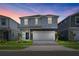 Two-story house with light gray siding, gray stone accents, and a two-car garage at 3955 Lana Ave, Davenport, FL 33897