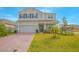 Two story house with brick paver driveway and landscaping at 5045 Rain Shadow Dr, St Cloud, FL 34772