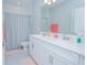 Clean bathroom with double vanity, shower/tub combo and striped curtain at 5045 Rain Shadow Dr, St Cloud, FL 34772