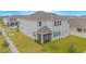 Two-story house with gray exterior, a screened porch, and a backyard at 5045 Rain Shadow Dr, St Cloud, FL 34772