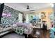 Studio apartment living area featuring a sofa, workspace, and tropical wallpaper at 706 E Pine St # 5, Orlando, FL 32801