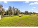 Spacious backyard with grassy lawn, pond, and mature trees at 1178 Michelangelo Ln, Winter Haven, FL 33884