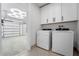 Bright laundry room with washer, dryer, and overhead cabinets at 1333 W Smith St, Orlando, FL 32804