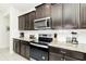 Well-equipped kitchen featuring dark wood cabinets and granite countertops at 287 Jetty Way, Davenport, FL 33897
