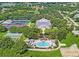 Aerial view of community featuring clubhouse, pool, tennis courts, and shuffleboard at 4538 Nottoway Dr, Leesburg, FL 34748