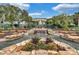 Landscaped water feature with bridge and lush tropical plants near clubhouse at 4538 Nottoway Dr, Leesburg, FL 34748