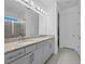 Double vanity bathroom with granite countertop and large mirror at 528 Bellissimo Pl, Howey In The Hills, FL 34737