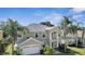 Two-story house with a large front yard, two-car garage, and palm trees at 10068 Chardonnay Dr, Orlando, FL 32832