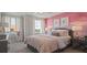 Bedroom with pink accent wall and rose bedding at 12614 Clear Sapphire Dr # 137, Winter Garden, FL 34787