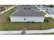 Rear view of a single-story house showing AC unit and backyard at 564 Boardwalk Ave, Haines City, FL 33844