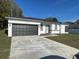 Modern house exterior with a two-car garage and well-maintained lawn at 6748 Cherry Rd, Ocala, FL 34472