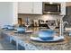 Granite kitchen island with seating for four, stainless steel appliances, and blue patterned bowls at 2719 Golden Trout Ln, Edgewater, FL 32141