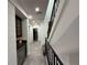 Modern hallway with sleek staircase, tiled floors, and built-in wet bar at 331 Muirfield Loop, Reunion, FL 34747