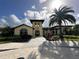 Inviting clubhouse entrance with palm trees and landscaping at 331 Muirfield Loop, Reunion, FL 34747