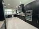 Modern kitchen featuring dark cabinetry and granite countertops at 331 Muirfield Loop, Reunion, FL 34747
