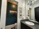 Elegant bathroom with dark vanity and teal accent wall at 331 Muirfield Loop, Reunion, FL 34747